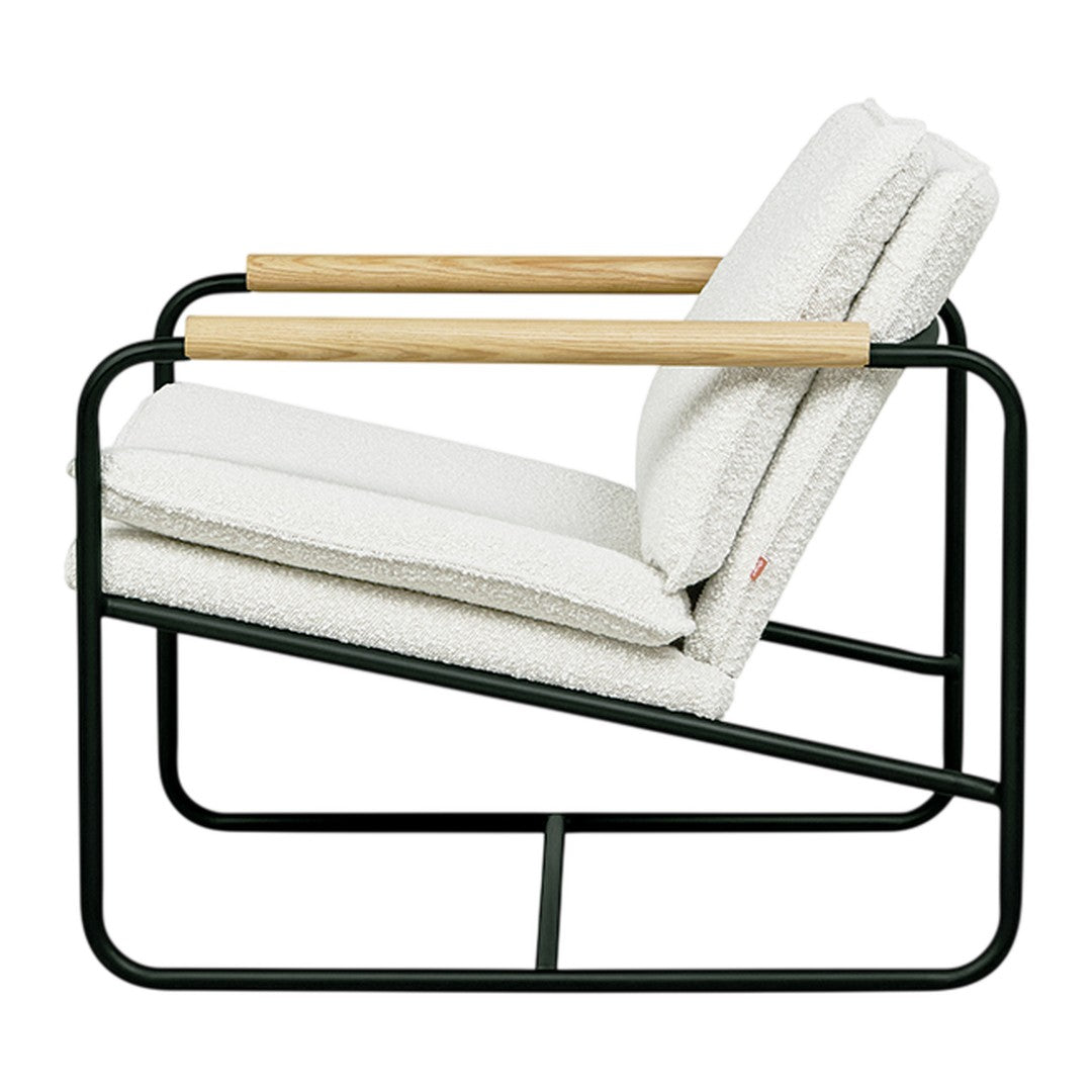 Cream upholstered chair with cozy texture, black metal frame, and natural wood armrest accents. Modern minimalist design.