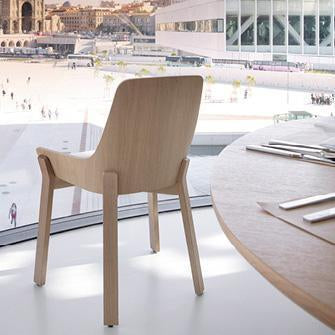 Natural wood chair with a sleek design, showcasing light beige tones and minimalistic patterns against a modern backdrop.