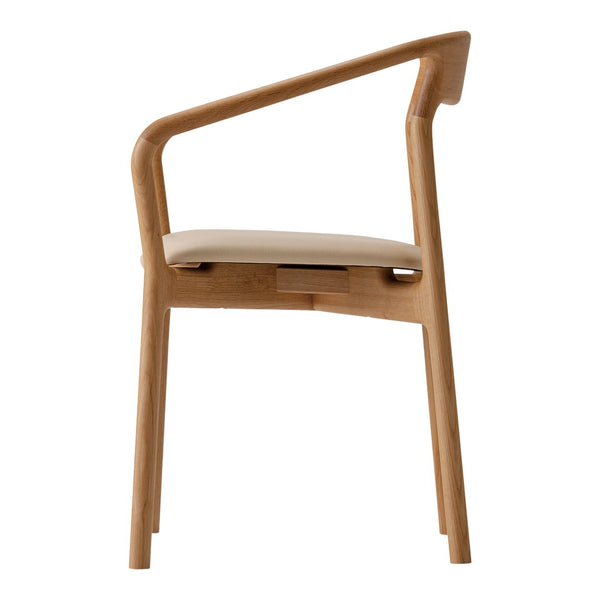 Light wood dining chair with a minimalist design and smooth beige seat cushion.
