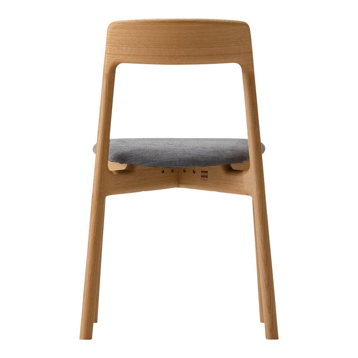 Modern wooden chair in natural wood finish with a soft gray upholstered seat. Simple and elegant design.