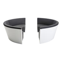 Modern black and gray upholstered chairs with sleek white backs, featuring a minimalist and contemporary design.
