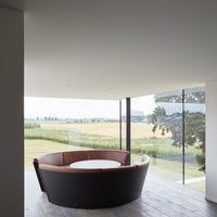 Round black and brown seating with a white tabletop, featuring a sleek modern design against a natural backdrop.