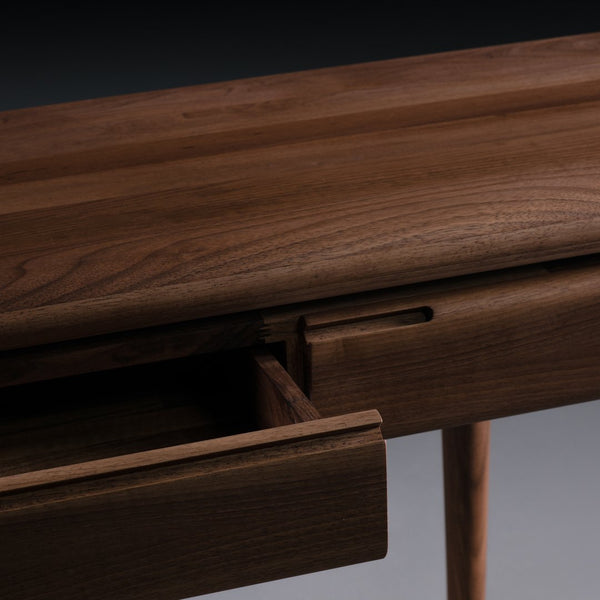 Close-up of a dark wood surface featuring a smooth finish and natural grain pattern, showcasing a modern design.