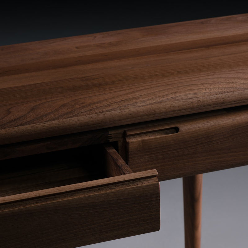 Close-up of a dark wood surface featuring a smooth finish and natural grain pattern, showcasing a modern design.