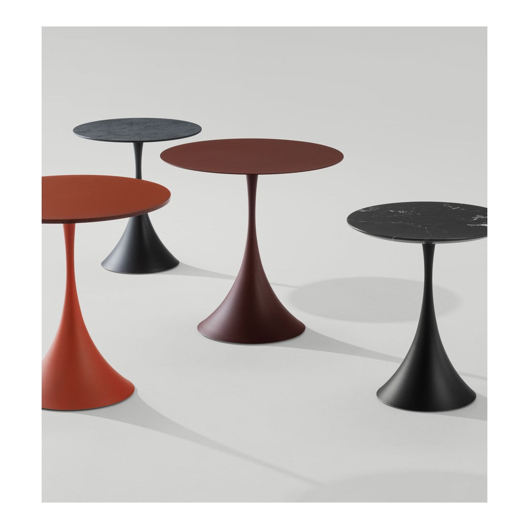"Four modern side tables in red, black, bronze, and gray with sleek, minimalist designs and smooth surfaces."