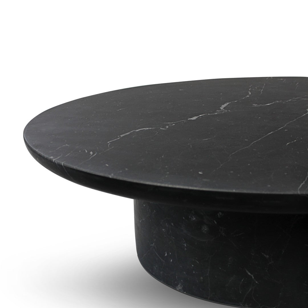 Black marble round table with subtle white veining, showcasing a sleek, modern design and elegant finish.