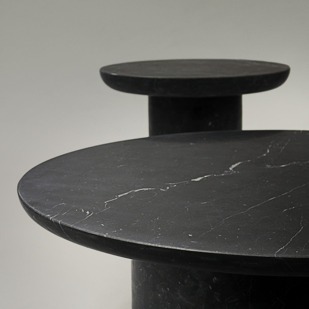 Elegant black marble tabletops with subtle white veining, featuring modern circular designs. Perfect for contemporary decor.