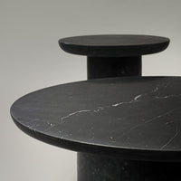 Elegant black marble tabletops with subtle white veining, featuring modern circular designs. Perfect for contemporary decor.