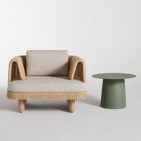 Beige patterned upholstery on a woven rattan chair paired with a minimalist green side table.