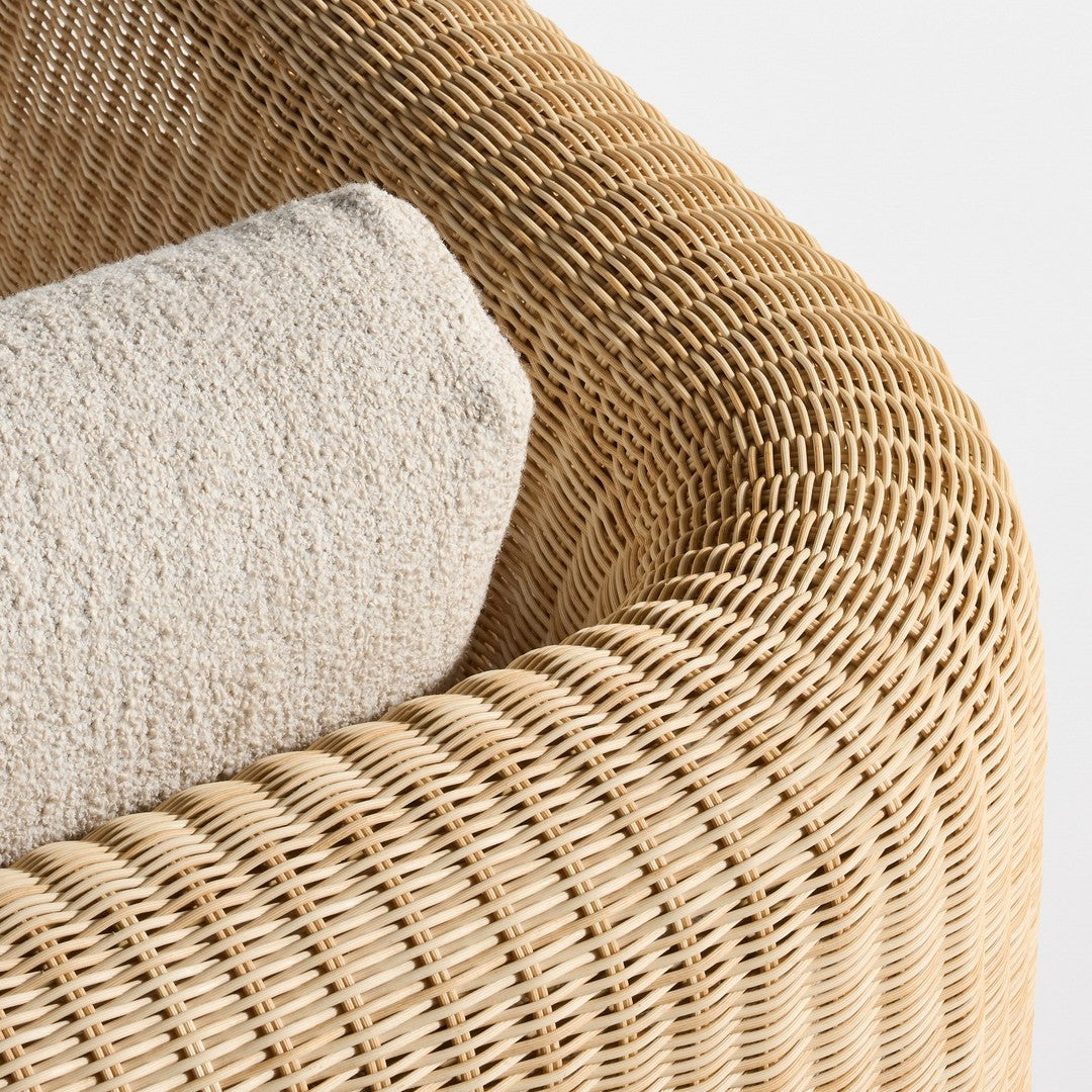 Textured beige cushion on a natural woven rattan chair with a warm, light brown tone and intricate pattern.
