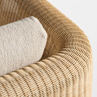 Textured beige cushion on a natural woven rattan chair with a warm, light brown tone and intricate pattern.