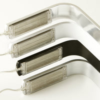 Set of sleek metal strips in silver and black with smooth, curved designs and rectangular light fixtures.