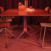 Modern red dining table with matching chairs, displaying rich hues and subtle patterns for a cohesive look.