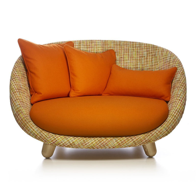Vibrant orange cushions on a woven pattern sofa, featuring a cozy curved design for stylish comfort.