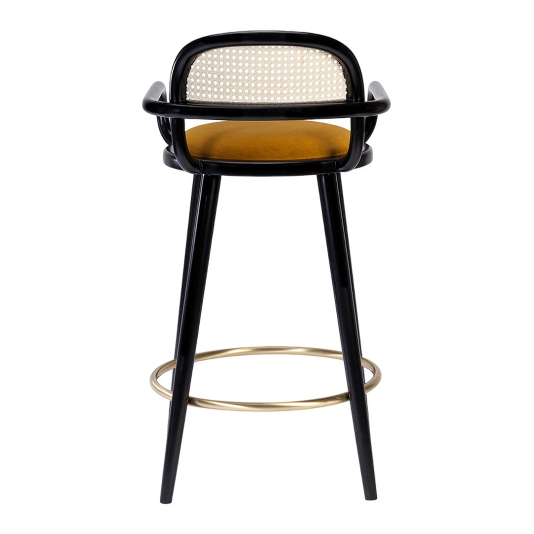 Black and gold bar stool with a rattan back and mustard yellow seat, combining modern and classic design elements.