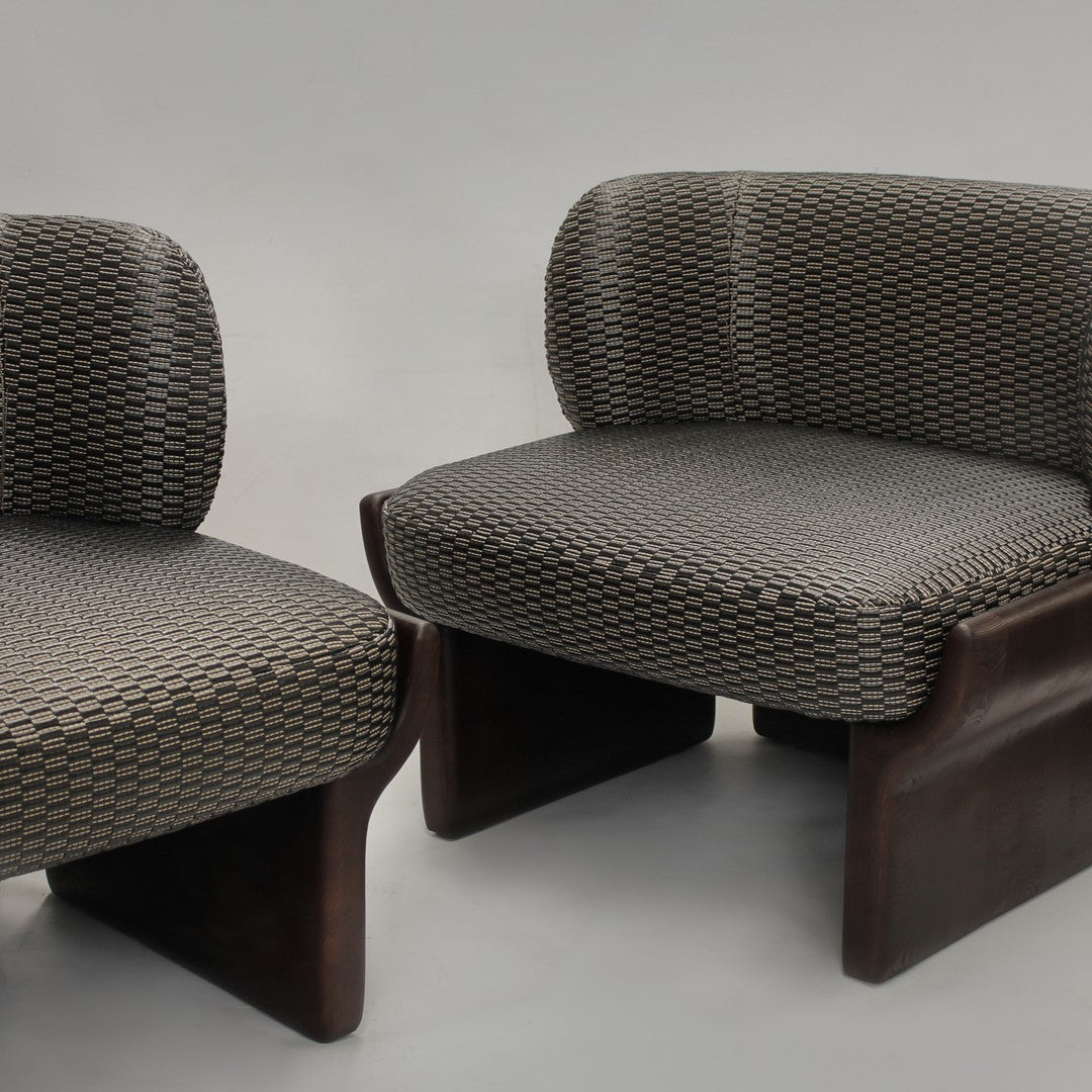 Gray patterned upholstery on modern chairs with dark wooden bases, featuring a geometric design.