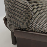 Brown and gray woven fabric with a textured checkered pattern on modern sofa armrest.