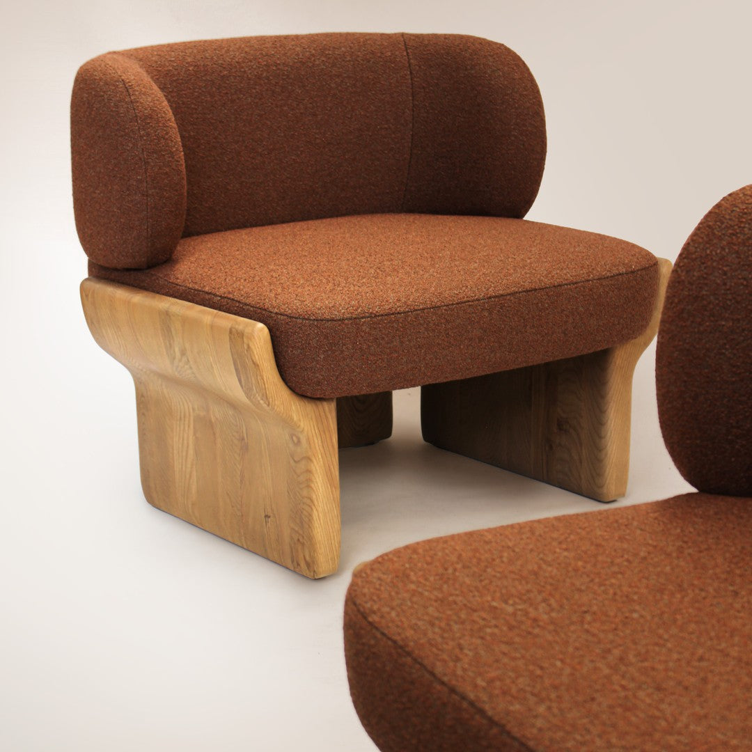 Brown textured upholstered chair with a wooden base, featuring a minimalist design and rounded backrest.
