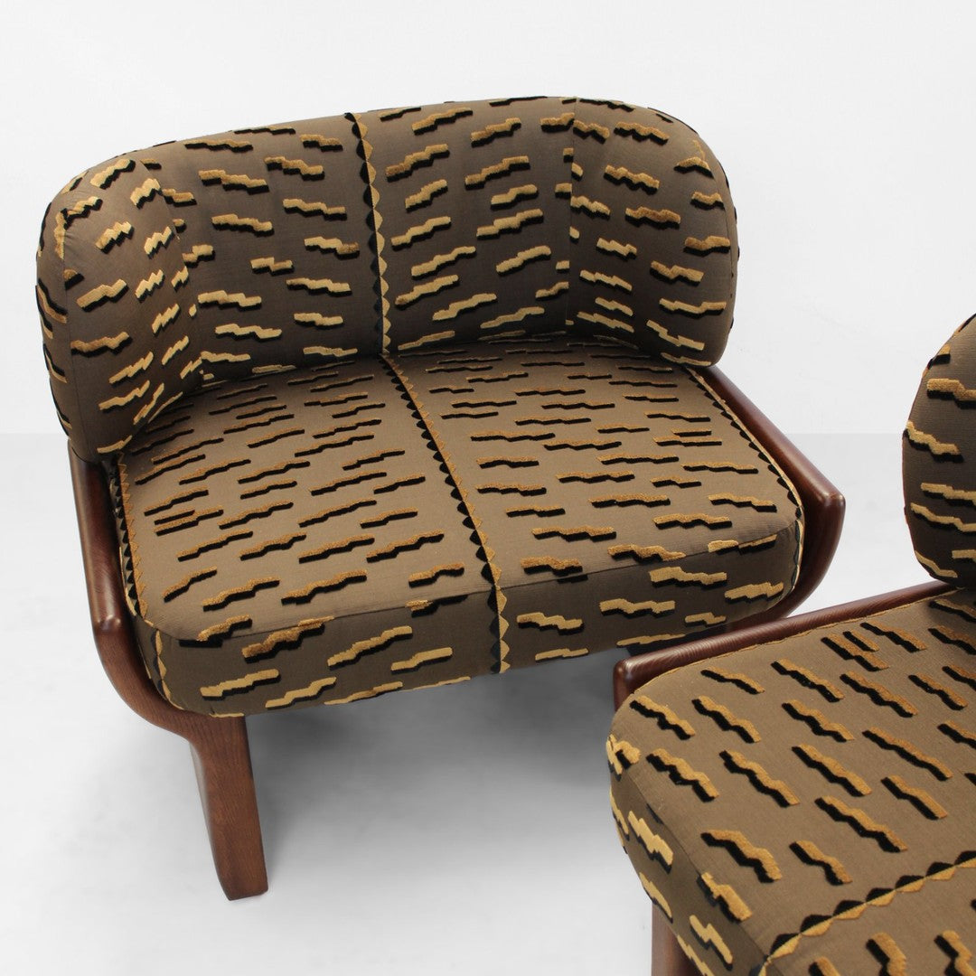 Brown couch with wavy yellow and dark brown patterns, featuring rounded cushions and a wooden frame.