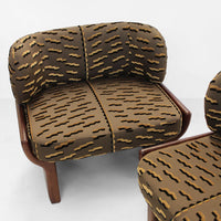 Brown couch with wavy yellow and dark brown patterns, featuring rounded cushions and a wooden frame.