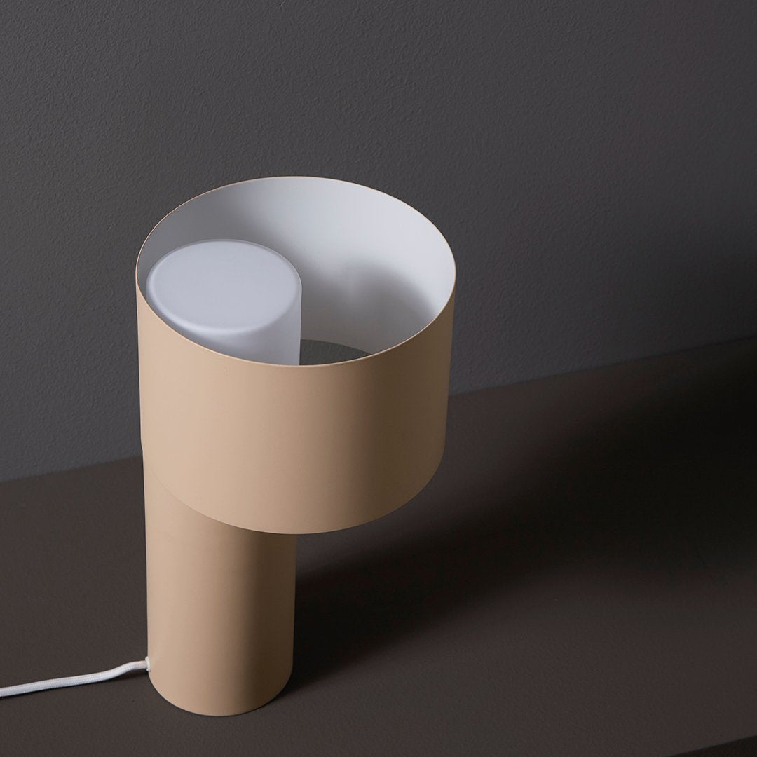 Beige and white modern lamp with a sleek, circular design and minimalistic structure on a dark background.
