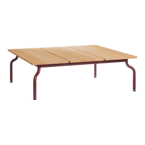 Wooden tabletop in a natural finish with burgundy metal legs, featuring a simple and sleek design.