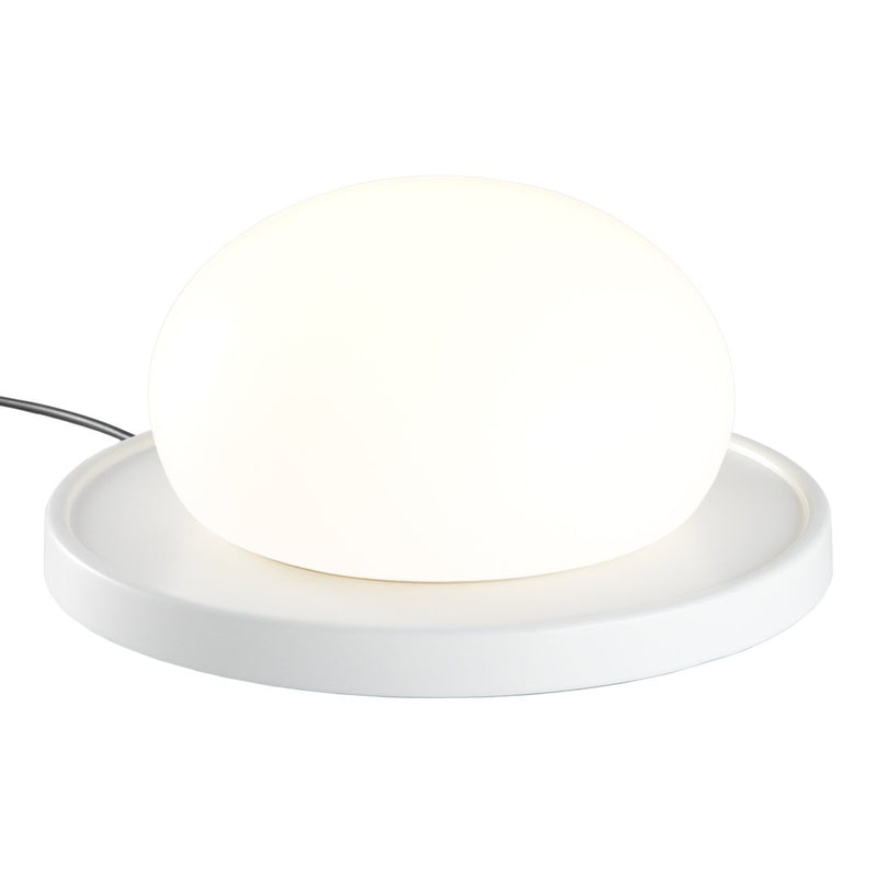 White oval lamp on a round white base, emitting a soft glow for a modern, minimalist look.