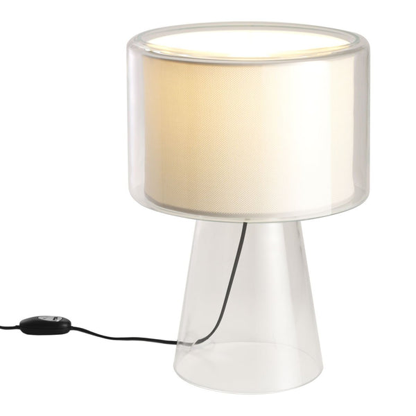 Clear glass lamp with a cylindrical white shade, featuring a minimalistic design and soft, neutral colors.
