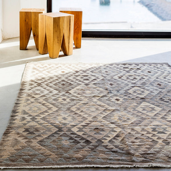 Beige and brown geometric patterned rug with diamond motifs and soft textures. Ideal for modern decor.