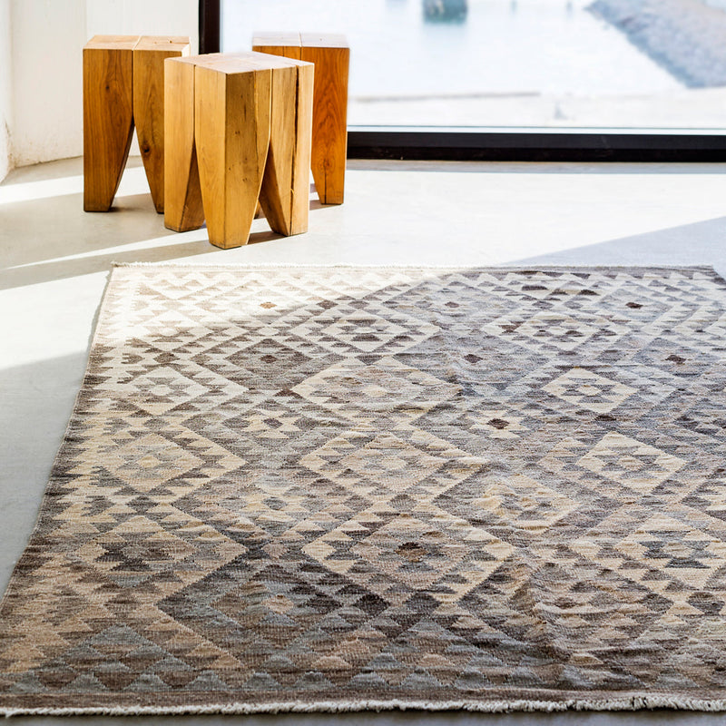 Beige and brown geometric patterned rug with diamond motifs and soft textures. Ideal for modern decor.