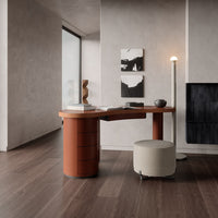 Contemporary desk in terracotta with smooth cream accent chair, set against a neutral-toned interior. Modern minimalist design.