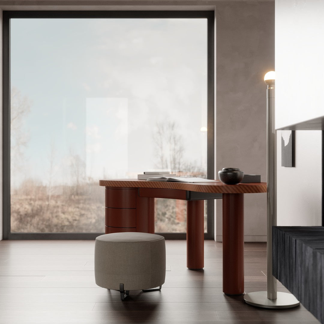 Natural wood desk in warm orange hues with a soft gray ottoman, set against a minimalist backdrop.