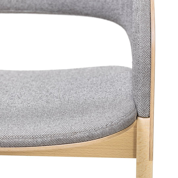 Gray textured upholstery on a wooden chair, featuring a subtle herringbone pattern.