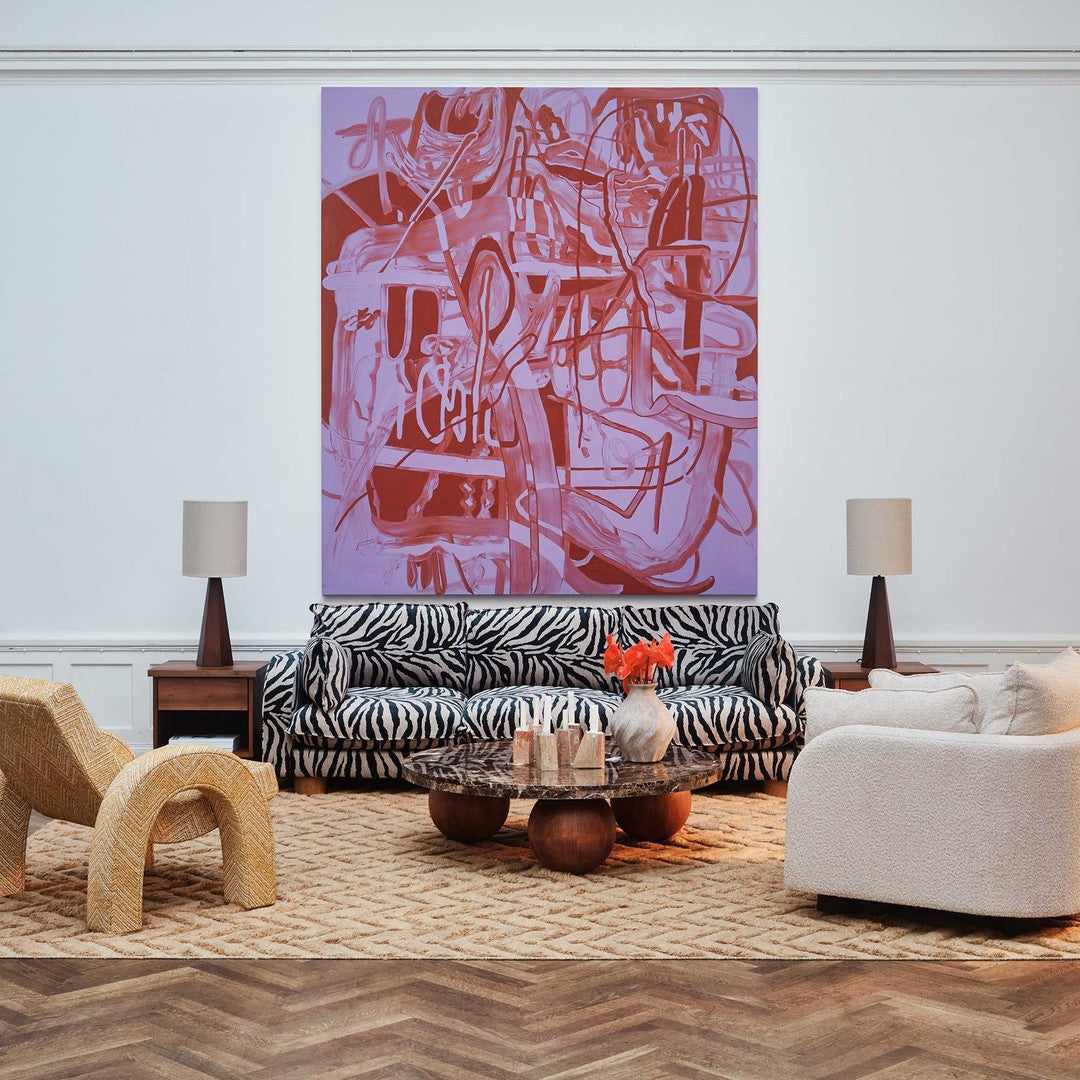 "Abstract wall art with purple and red patterns above a black and white striped sofa in a chic living room."