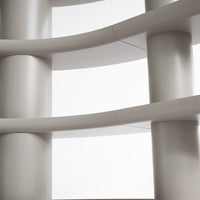 Curved white columns create a modern and minimalistic pattern against a clean, pale backdrop.