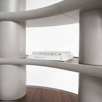 Modern shelving unit featuring soft gray curves and rich wood accents with minimalist white books on display.