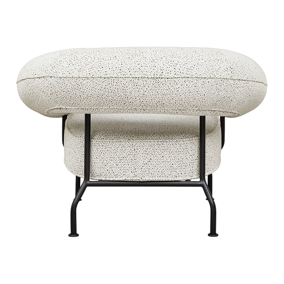 Cream textured ottoman with a speckled pattern and sleek black metal frame. Perfect for modern decor.