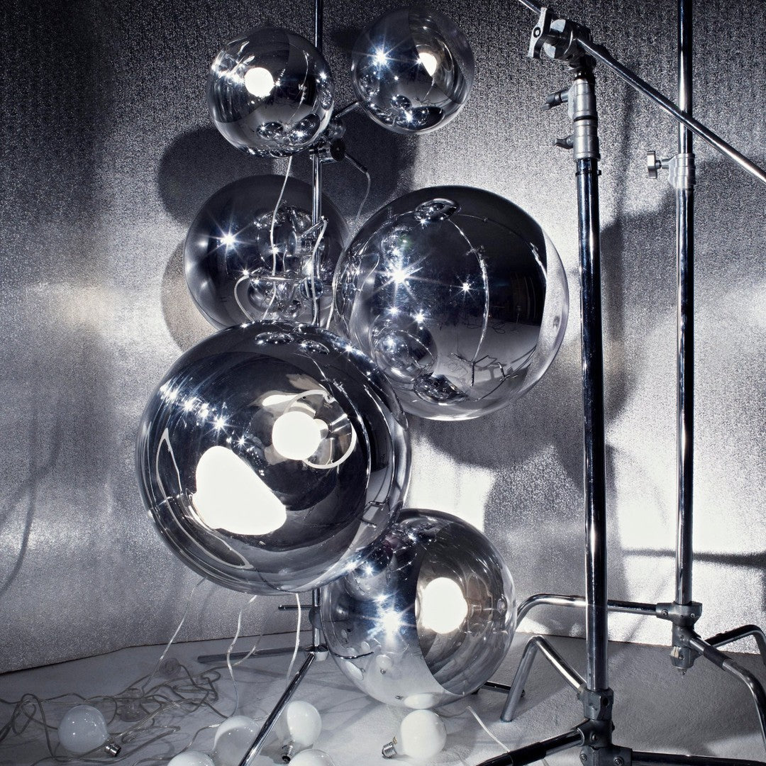 Silver reflective balloons in various sizes, showcasing a glossy metallic finish and intricate light patterns.