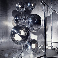 Silver reflective balloons in various sizes, showcasing a glossy metallic finish and intricate light patterns.