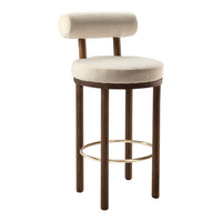 Cream-colored upholstered bar stool with a rounded back and dark wooden legs, featuring a sleek gold footrest.