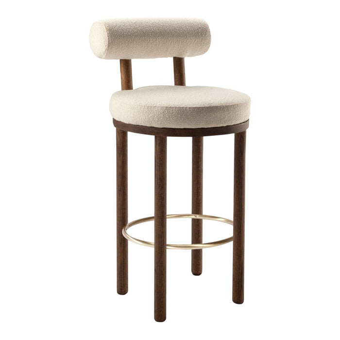 Cream-colored upholstered bar stool with a rounded back and dark wooden legs, featuring a sleek gold footrest.