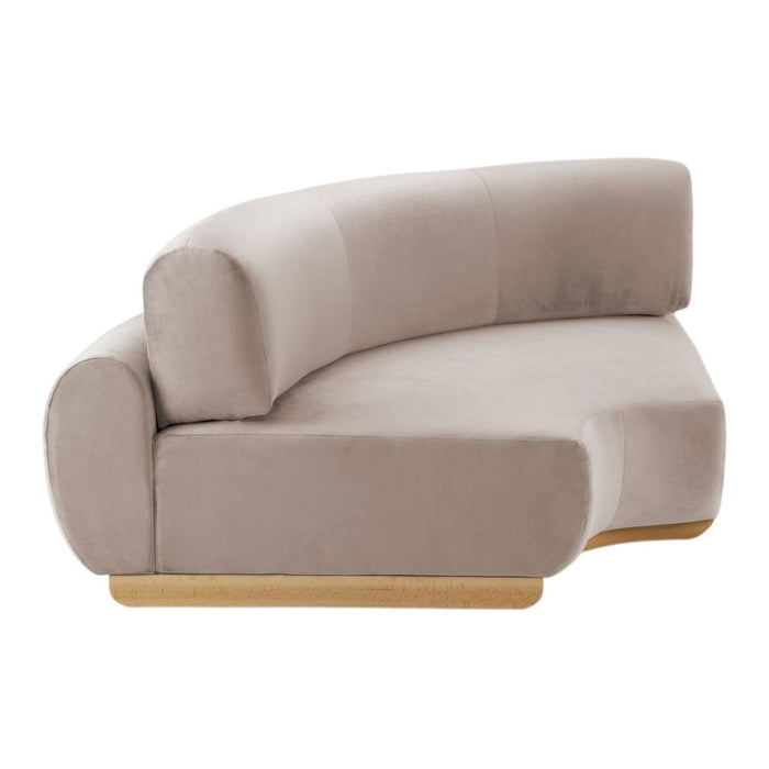 Curved beige sofa with soft velvet upholstery and wooden base, featuring a minimalist and modern design.