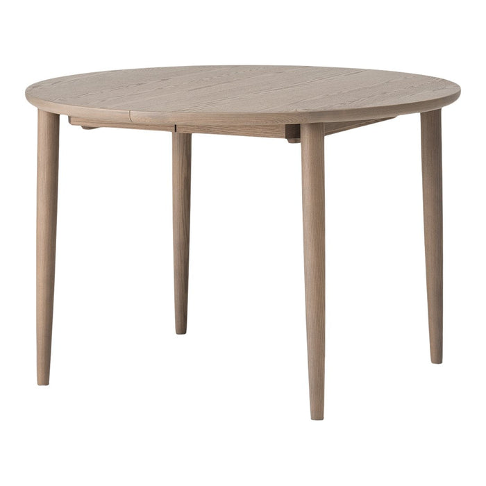 Round wooden table in a light oak finish with a smooth, natural wood grain pattern. Ideal for modern dining spaces.