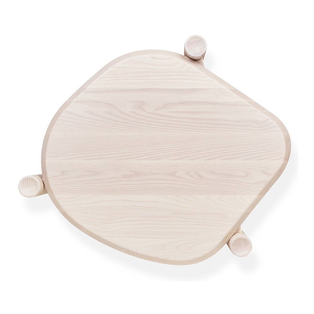Light wood table with a soft, organic shape and rounded edges, showcasing a smooth natural grain pattern.