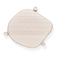 Light wood table with a soft, organic shape and rounded edges, showcasing a smooth natural grain pattern.