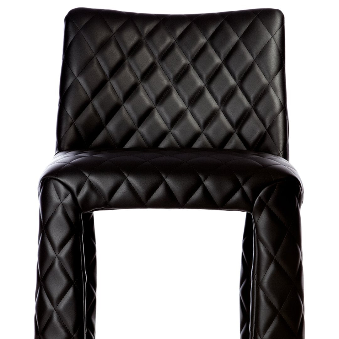 Black quilted barstool with a stylish diamond pattern for a modern touch. Perfect for contemporary interiors.