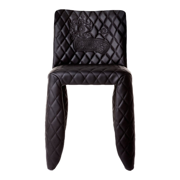 Black quilted chair featuring a diamond pattern and embossed design, adding a touch of elegance to any space.