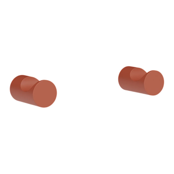 "Pair of round muted terracotta-colored knobs, smooth surface with a contemporary design."