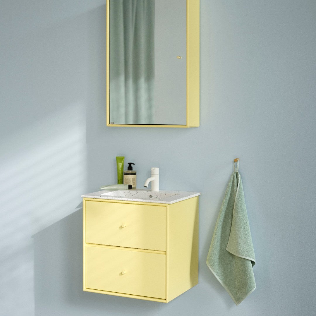 Yellow bathroom vanity with two drawers, white countertop, and a pale green towel against a light blue wall.