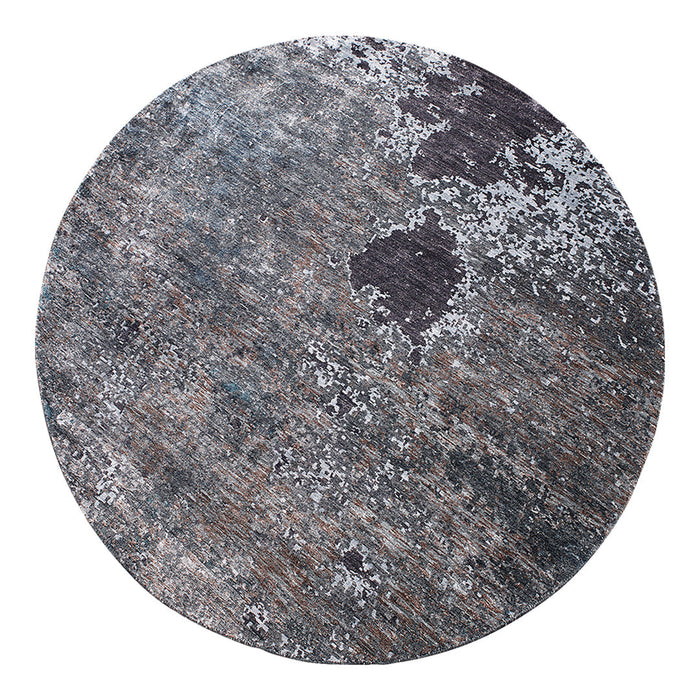 Round rug featuring a textured blend of gray, black, and hints of brown in a modern, abstract pattern.